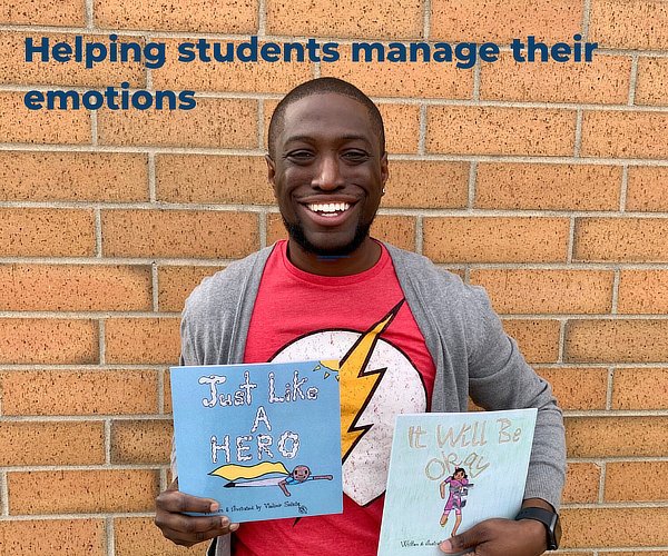 Vladimir Sainte holding the Just Like A Hero series books
